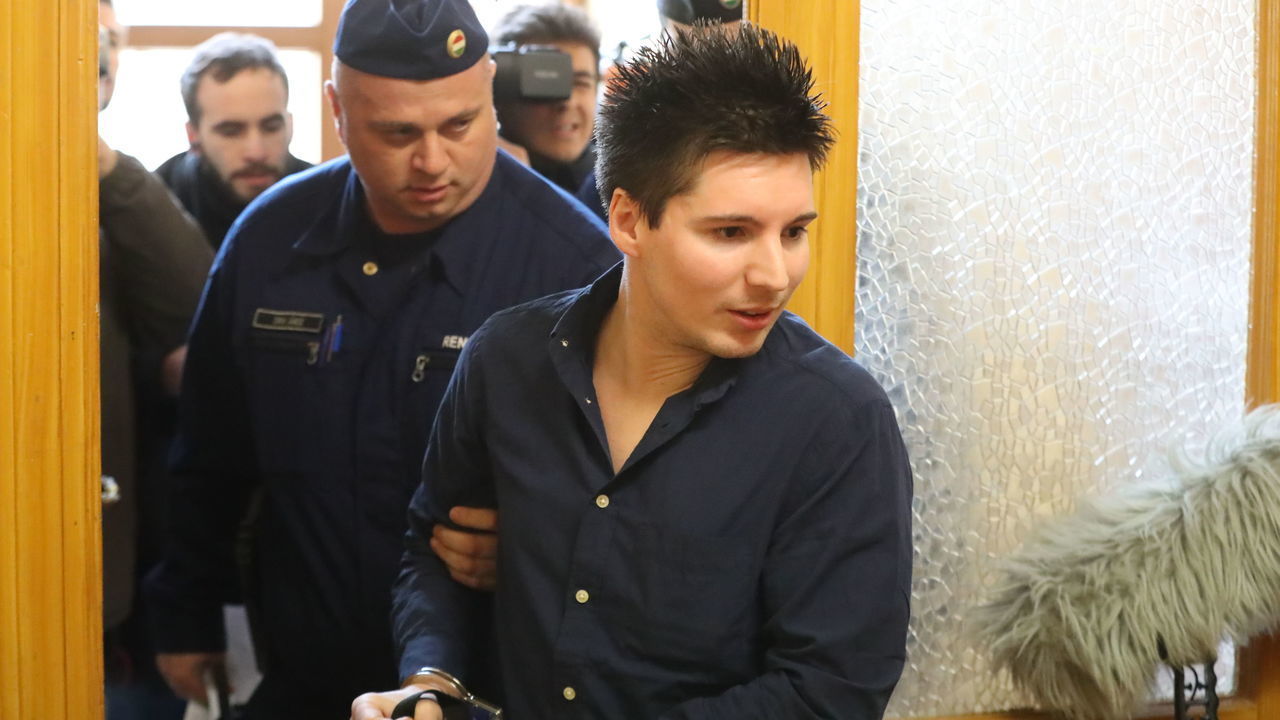 Football Leaks whistleblower Rui Pinto (R) is escorted by a judicial officer as he arrives at the Metropolitan Court in Budapest, Hungary, for his trial on March 5, 2019. - The court has approved the extradition of the Portuguese hacker linked to the Football Leaks website that has exposed alleged corruption, sparking investigations in several European countries.