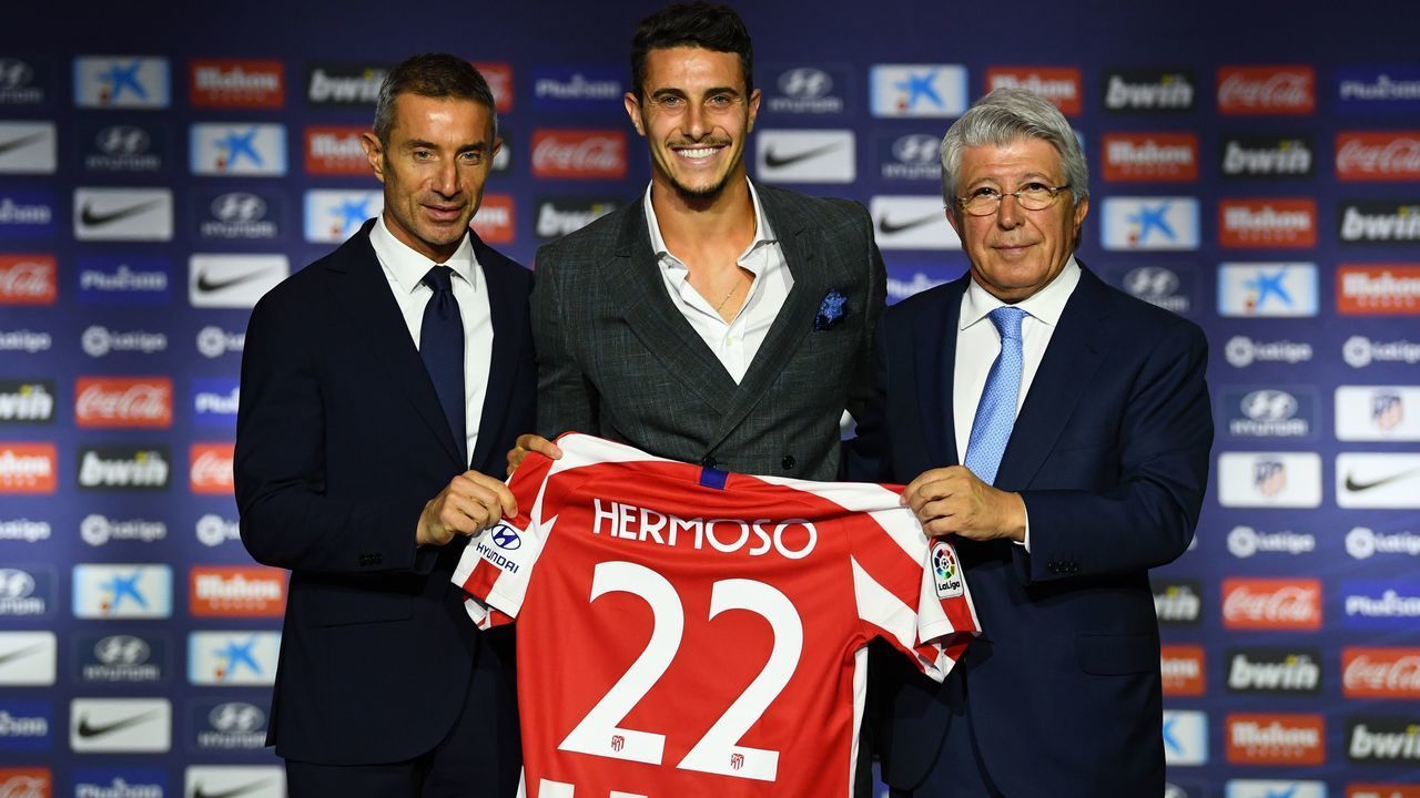 Atletico Madrid's new Spanish defender Mario Hermoso poses with his new jersey next to the Spanish football club's president Enrique Cerezo (R) and sports director Andrea Berta (L) during his official presentation at the Wanda Metropolitano stadium in Madrid on July 18, 2019.