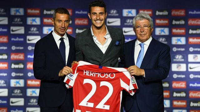 Atletico Madrid's new Spanish defender Mario Hermoso poses with his new jersey next to the Spanish football club's president Enrique Cerezo (R) and sports director Andrea Berta (L) during his official presentation at the Wanda Metropolitano stadium in Madrid on July 18, 2019.