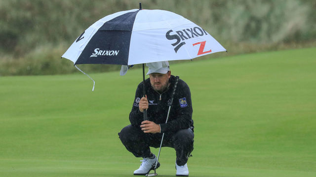 PORTRUSH, NORTHERN IRELAND - JULY 18: Graeme McDowell of Northern Ireland shelters from a rain shower during the first round of the 148th Open Championship held on the Dunluce Links at Royal Portrush Golf Club on July 18, 2019 in Portrush, United Kingdom.
