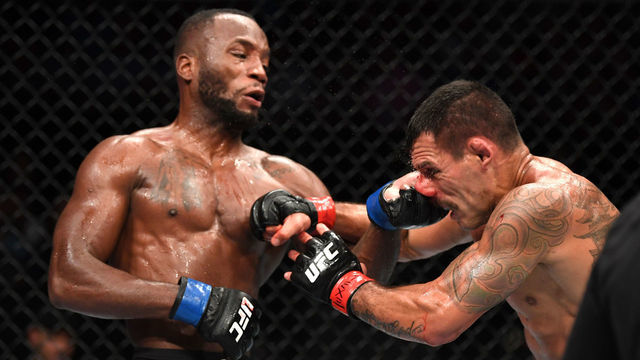 SAN ANTONIO, TEXAS - JULY 20: (L-R) Leon Edwards of Jamaica punches Rafael Dos Anjos of Brazil in their welterweight bout during the UFC Fight Night event at AT&T Center on July 20, 2019 in San Antonio, Texas.