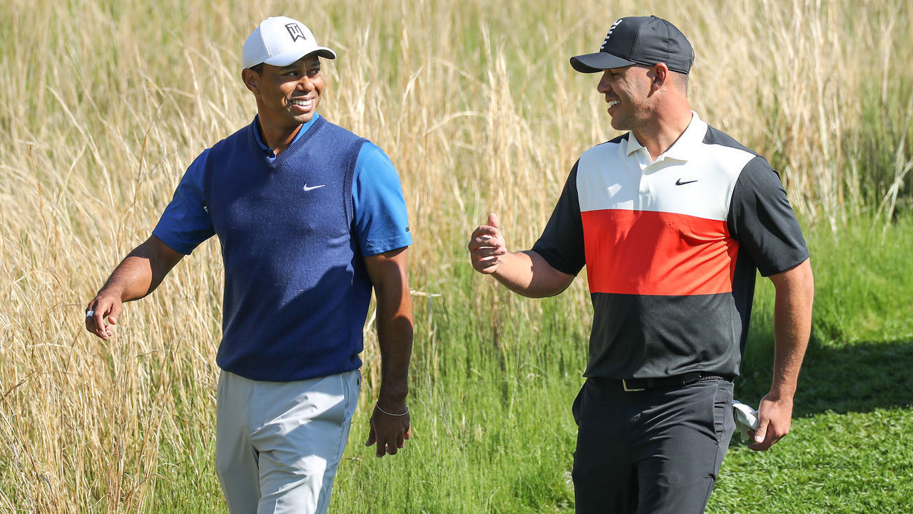 FARMINGDALE, NEW YORK - MAY 16: Tiger Woods of the United States walks off the 13th tee with his playing partner Brooks Koepka of the United States during the first round of the 2019 PGA Championship on the Black Course at Bethpage State Park on May 16, 2019 in Farmingdale, New York.