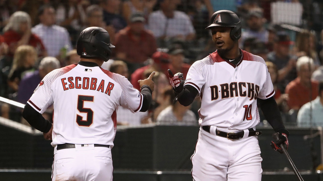 PHOENIX, ARIZONA - JULY 22: Adam Jones #10 of the Arizona Diamondbacks high fives Eduardo Escobar #5 after scoring against the Baltimore Orioles during first inning of the MLB game at Chase Field on July 22, 2019 in Phoenix, Arizona.
