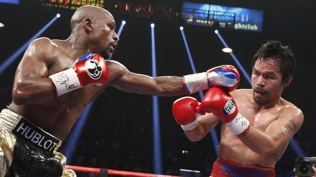 Floyd Mayweather Jr. exchange punches with Manny Pacquiao during their welterweight unification championship bout, May 2, 2015 at MGM Grand Garden Arena in Las Vegas, Nevada. Mayweather defeated Pacquiao by unanimous decision. AFP PHOTO / JOHN GURZINKSI