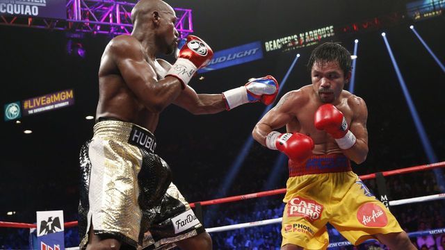 Floyd Mayweather Jr. exchange punches with Manny Pacquiao during their welterweight unification championship bout, May 2, 2015 at MGM Grand Garden Arena in Las Vegas, Nevada. Mayweather defeated Pacquiao by unanimous decision. AFP PHOTO / JOHN GURZINKSI