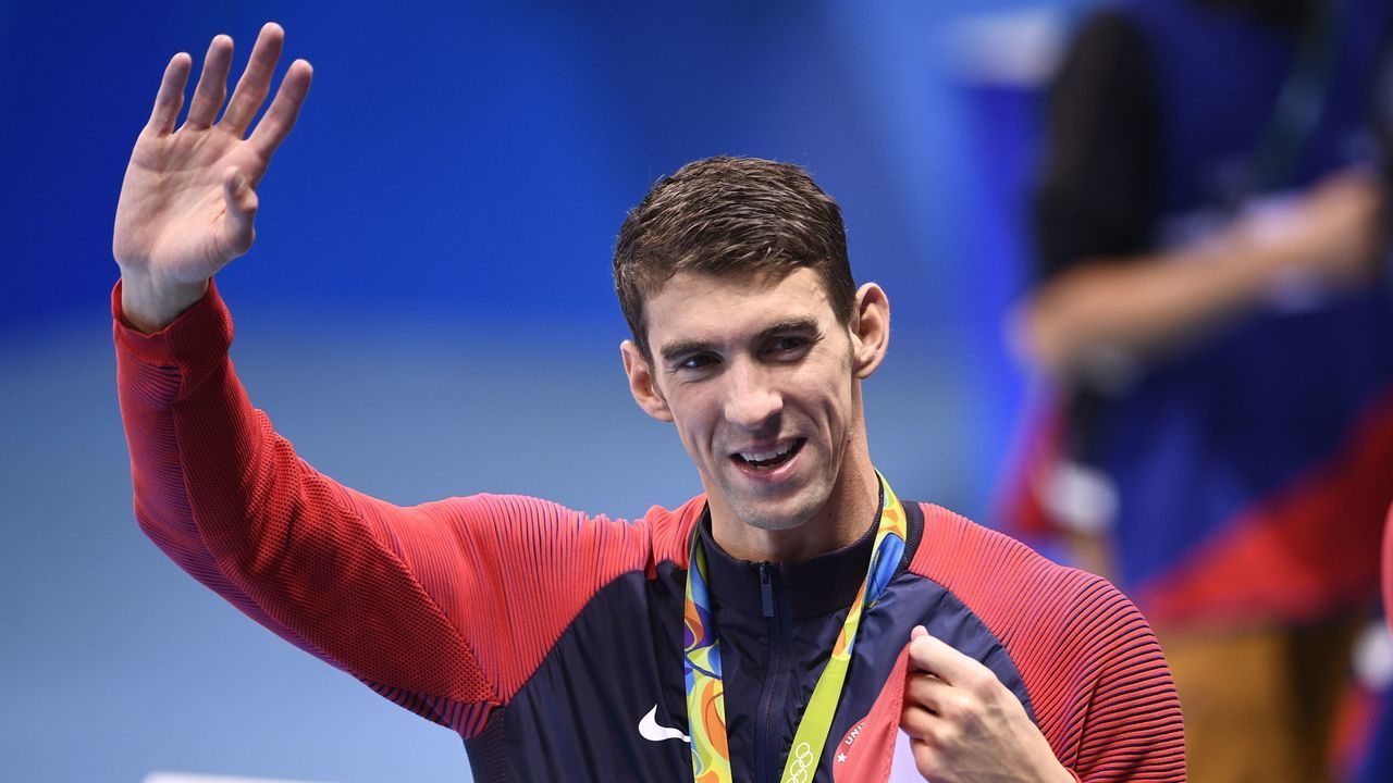 USA's gold medallist Michael Phelps waves after the podium ceremony of the Men's swimming 4 x 100m Medley Relay Final at the Rio 2016 Olympic Games at the Olympic Aquatics Stadium in Rio de Janeiro on August 13, 2016. / AFP / Martin BUREAU