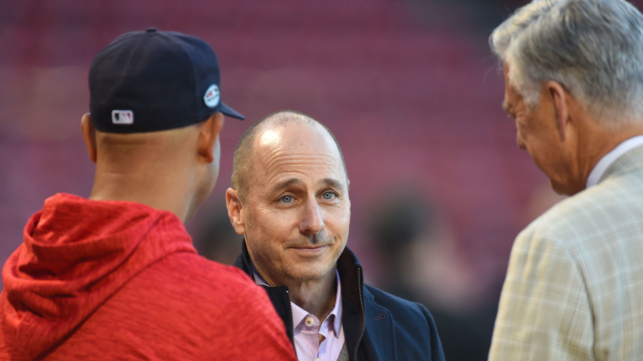 BOSTON, MA. - OCTOBER 5: New York Yankees general manager Brian Cashman, center, talks with Alex Cora #20 of the Boston Red Sox, left, and Red Sox president of baseball operations Dave Dombrowski prior to the start of Game 1 of Major League Baseball's American League Division Series at Fenway Park in Boston, Massachusetts on October 5, 2018.