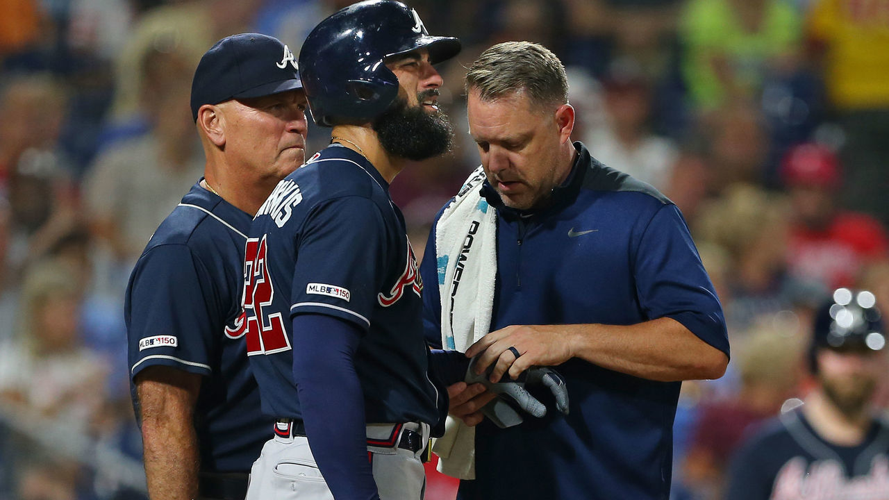 PHILADELPHIA, PA - JULY 26: Nick Markakis #22 of the Atlanta Braves is looked at by a member of the team's medical staff along with manager Brian Snitker #43 after getting hit in the hand by a pitch during the sixth inning of a game against the Philadelphia Phillies at Citizens Bank Park on July 26, 2019 in Philadelphia, Pennsylvania. The Braves defeated the Phillies 9-2.