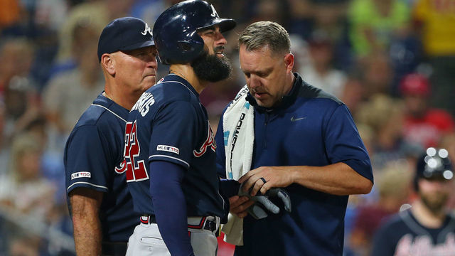 PHILADELPHIA, PA - JULY 26: Nick Markakis #22 of the Atlanta Braves is looked at by a member of the team's medical staff along with manager Brian Snitker #43 after getting hit in the hand by a pitch during the sixth inning of a game against the Philadelphia Phillies at Citizens Bank Park on July 26, 2019 in Philadelphia, Pennsylvania. The Braves defeated the Phillies 9-2.