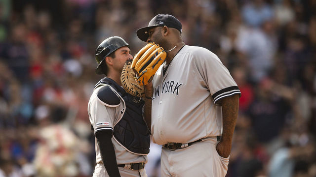 BOSTON, MA - JULY 27: CC Sabathia #52 of the New York Yankees talks with Kyle Higashioka #66 during the second inning of a game against the Boston Red Sox on July 27, 2019 at Fenway Park in Boston, Massachusetts.