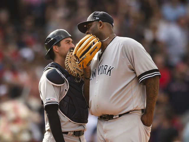 New York Yankees starting pitcher CC Sabathia hands the ball to Aaron Boone  who is already holding a baseball as he is replaced against the Seattle  Mariners during the sixth inning of