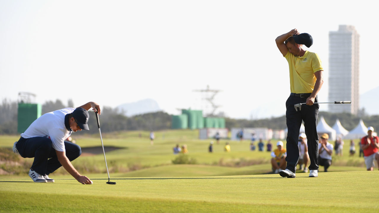 RIO DE JANEIRO, BRAZIL - AUGUST 14: Henrik Stenson of Sweden reacts as Justin Rose of Great Britain lines up a putt during the final round of men's golf on Day 9 of the Rio 2016 Olympic Games at the Olympic Golf Course on August 14, 2016 in Rio de Janeiro, Brazil.