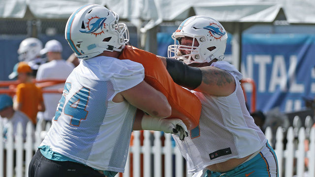 DAVIE, FL - JULY 26: Chris Reed #64 and Daniel Kilgore #67 of the Miami Dolphins runs a drill during the Miami Dolphins Training Camp at the Miami Dolphins training facility on July 26, 2019 in Davie, Florida.