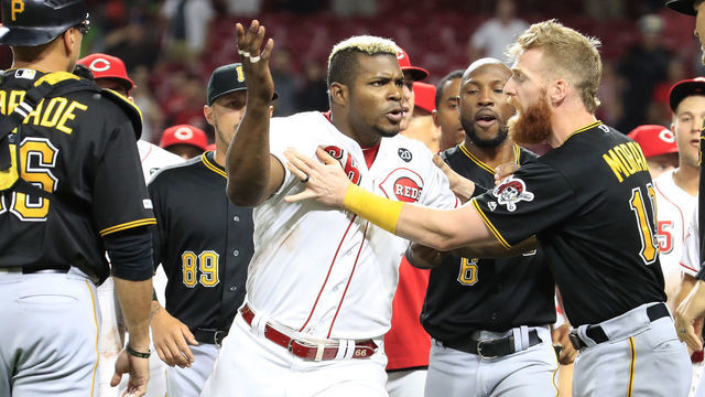 CINCINNATI, OHIO - JULY 30: Yasiel Puig #66 of the Cincinnati Reds is restrained during a bench clearing altercation in the 9th inning of the game against the Pittsburgh Pirates at Great American Ball Park on July 30, 2019 in Cincinnati, Ohio.
