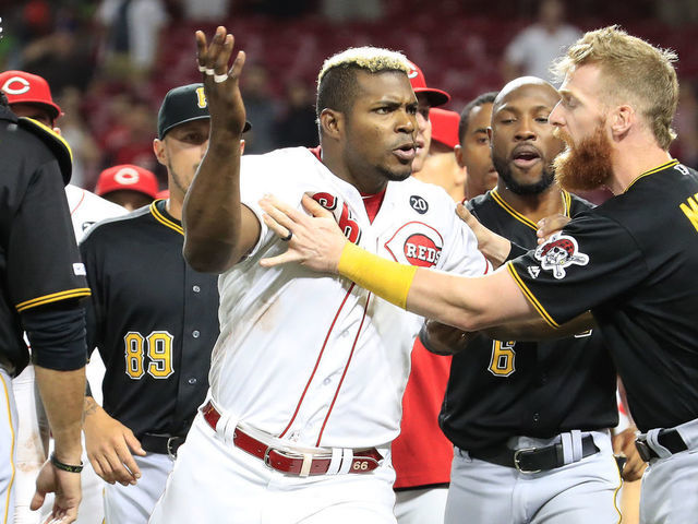 CINCINNATI, OHIO - JULY 30: Yasiel Puig #66 of the Cincinnati Reds is restrained during a bench clearing altercation in the 9th inning of the game against the Pittsburgh Pirates at Great American Ball Park on July 30, 2019 in Cincinnati, Ohio.