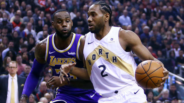 TORONTO, ON - MARCH 14: Kawhi Leonard #2 of the Toronto Raptors dribbles the ball as LeBron James #23 of the Los Angeles Lakers defends during the first half of an NBA game at Scotiabank Arena on March 14, 2019 in Toronto, Canada.