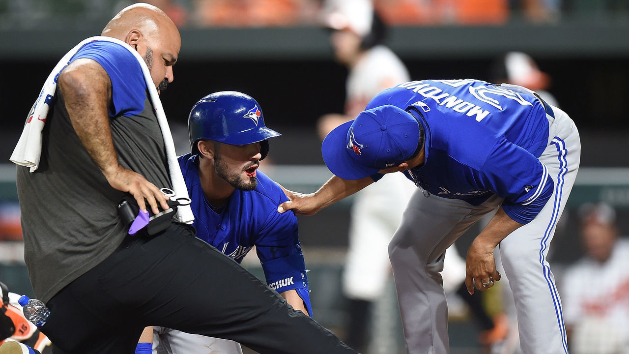 BALTIMORE, MD - AUGUST 01: Randal Grichuk #15 of the Toronto Blue Jays is checked by manager Charlie Montoyo #25 and assistant athletic trainer Jose Ministral after fouling a pitch into his face in the ninth inning against the Baltimore Orioles at Oriole Park at Camden Yards on August 1, 2019 in Baltimore, Maryland.