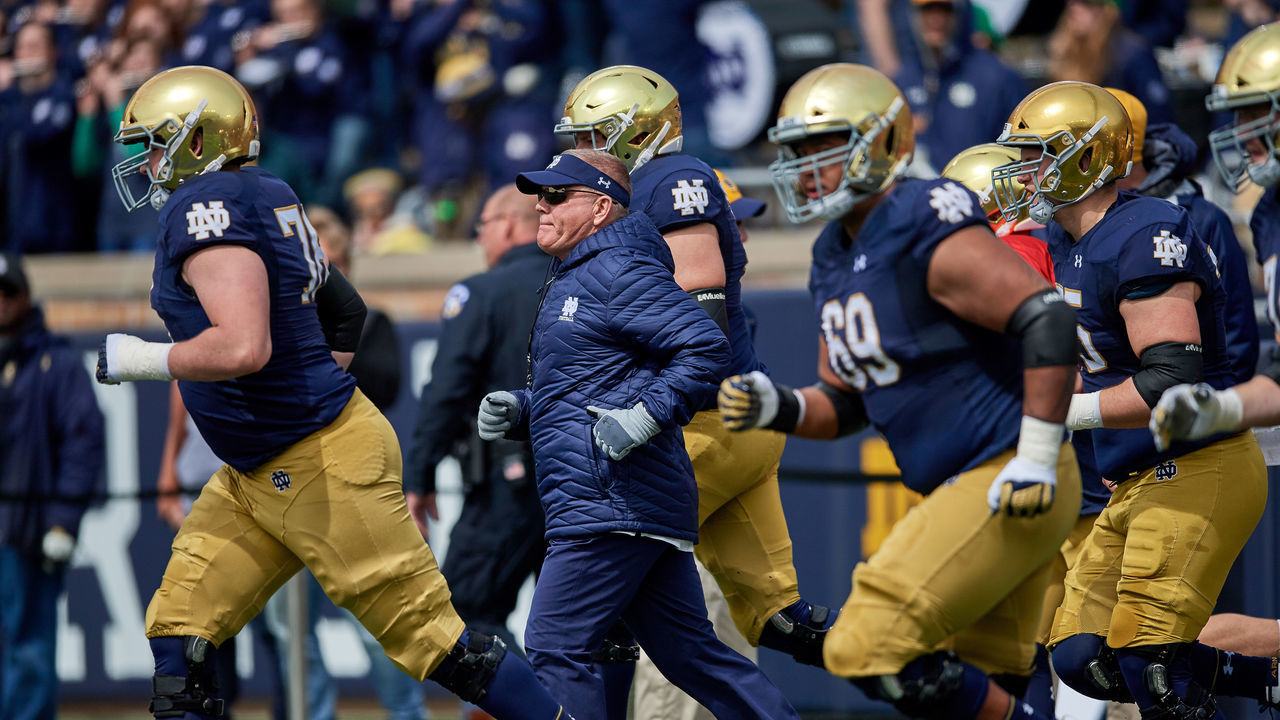 SOUTH BEND, IN - APRIL 13: Notre Dame Fighting Irish head coach Brian Kelly runs out with all the players prior to game action during the Notre Dame Football Blue and Gold Spring game on April 13, 2019 at Notre Dame Stadium in South Bend, IN.