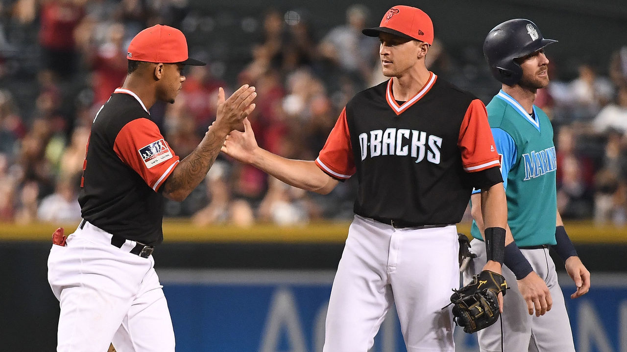 PHOENIX, AZ - AUGUST 26: Ketel Marte #4 and Nick Ahmed #13 of the Arizona Diamondbacks celebrate after turning a double play to end the game against the Seattle Mariners at Chase Field on August 26, 2018 in Phoenix, Arizona. All players across MLB wear nicknames on their backs as well as colorful, non-traditional uniforms featuring alternate designs inspired by youth-league uniforms during Players Weekend. The Arizona Diamondbacks won 5-2.
