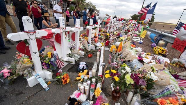 TOPSHOT - People leave flowers at a makeshift memorial for shooting victims at the Cielo Vista Mall Walmart, in El Paso, Texas, on August 6, 2019. - The August 3 shooting left 22 people dead. US President Donald Trump will visit the Texan border city August 7, and will also travel to Dayton, Ohio where a second mass shooting early August 4 left another nine dead.