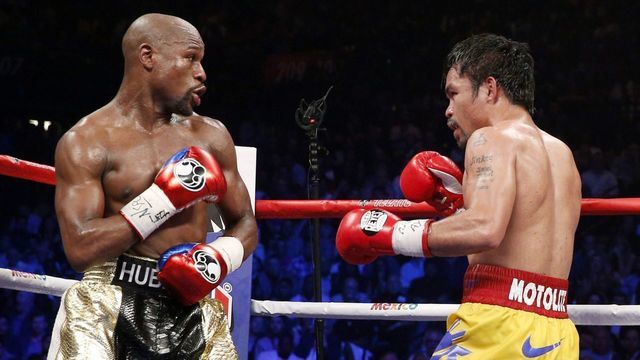 Floyd Mayweather Jr. exchange punches with Manny Pacquiao during their welterweight unification championship bout, May 2, 2015 at MGM Grand Garden Arena in Las Vegas, Nevada. Mayweather defeated Pacquiao by unanimous decision. AFP PHOTO / JOHN GURZINKSI