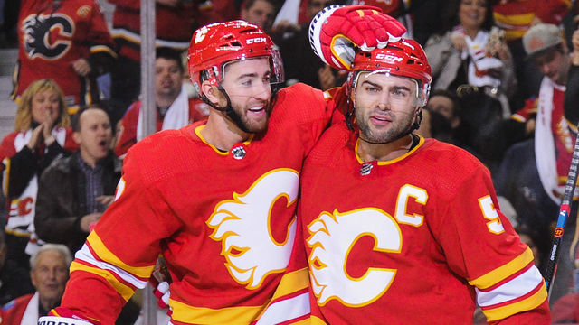 CALGARY, AB - OCTOBER 6: T.J. Brodie #7 celebrates with Mark Giordano #5 of the Calgary Flames after Giordano scored the Flames' second goal against the Vancouver Canucks during an NHL game at Scotiabank Saddledome on October 6, 2018 in Calgary, Alberta, Canada.