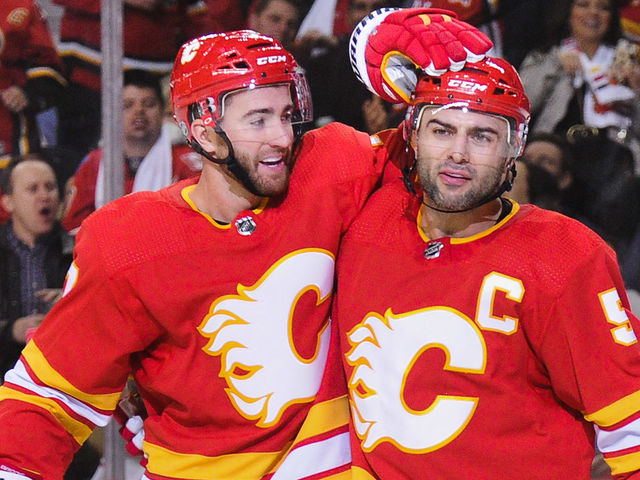 CALGARY, AB - OCTOBER 6: T.J. Brodie #7 celebrates with Mark Giordano #5 of the Calgary Flames after Giordano scored the Flames' second goal against the Vancouver Canucks during an NHL game at Scotiabank Saddledome on October 6, 2018 in Calgary, Alberta, Canada.