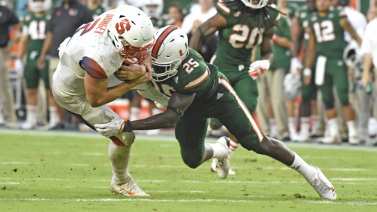 MIAMI GARDENS, FL - OCTOBER 21: University of Miami defensive back Derrick Smith (25) tackles Syracuse quarterback Eric Dungey (2) during an NCAA football game between the Syracuse University Orange and the University of Miami Hurricanes on October 21, 2017 at Hard Rock Stadium, Miami Gardens, Florida. Miami defeated Syracuse 27-19.