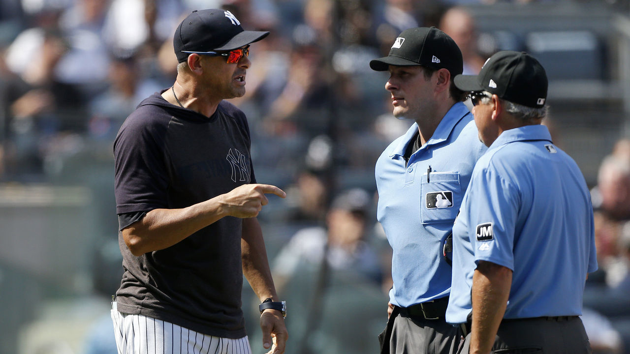 NEW YORK, NEW YORK - AUGUST 17: Manager Aaron Boone #17 of the New York Yankees argues with home plate umpire Ben May and second base umpire Tom Hallion (R) during the sixth inning of a game against the Cleveland Indians at Yankee Stadium on August 17, 2019 in New York City. The Yankees defeated the Indians 6-5.