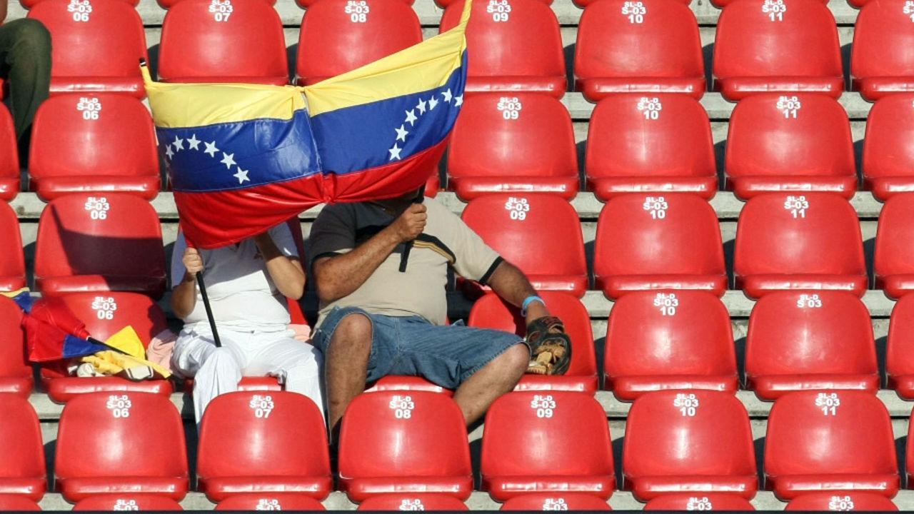 ISLA MARGARITA, VENEZUELA - FEBRUARY 07: Supporters protect from the sun with a Venezuela's flag during the game between Puerto Rico's Indios de Mayaguez v Mexico's Naranjeros de Hermosillo as part of the Caribbean Baseball Series 2010 at Guatamare Stadium on February 07, 2010 in Isla Margarita, Venezuela.