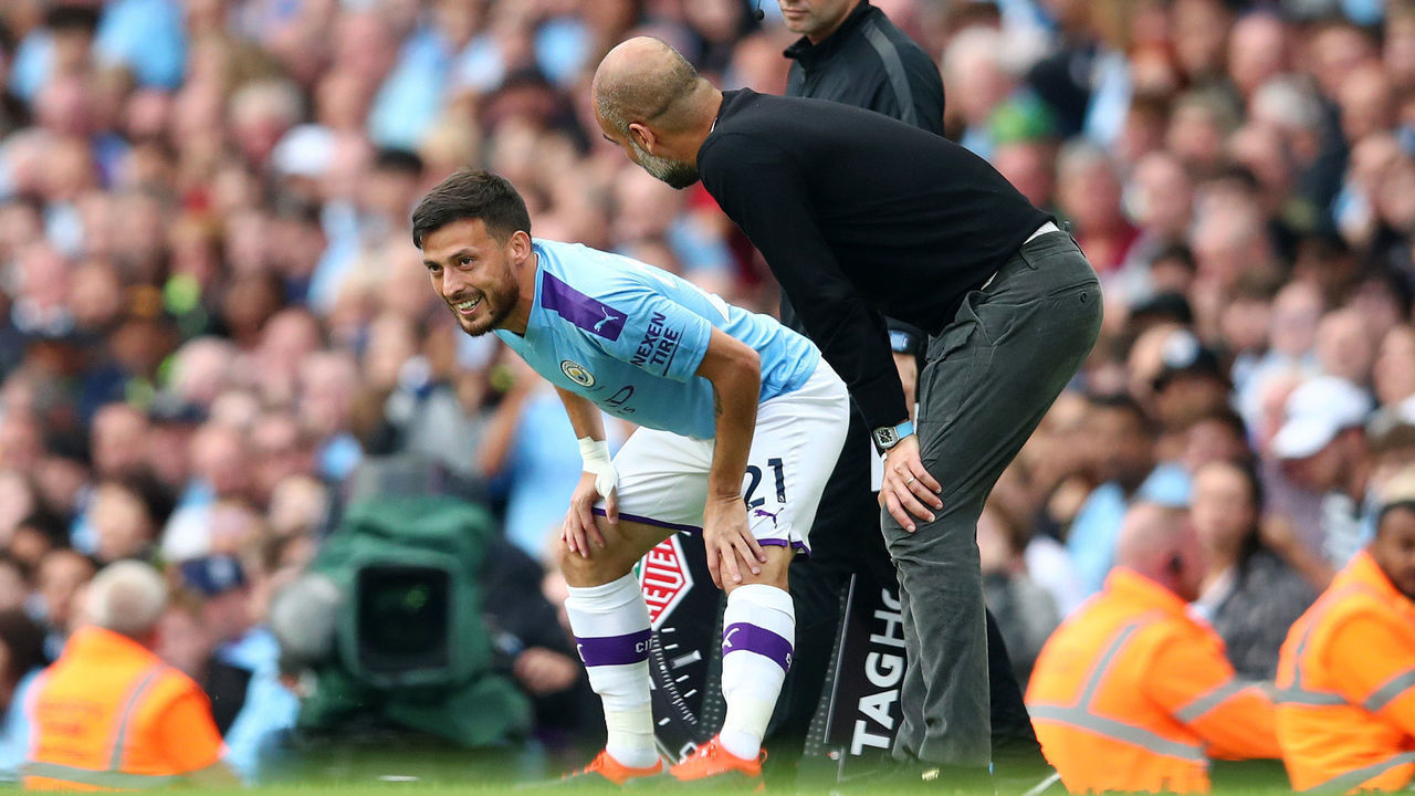MANCHESTER, ENGLAND - AUGUST 17: Pep Guardiola, Manager of Manchester City (R) speaks with David Silva of Manchester City on the side lines during the Premier League match between Manchester City and Tottenham Hotspur at Etihad Stadium on August 17, 2019 in Manchester, United Kingdom.