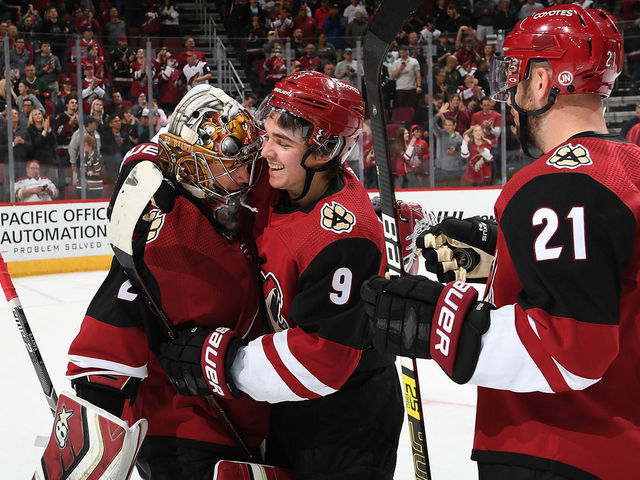 GLENDALE, AZ - NOVEMBER 02: Clayton Keller #9 of the Arizona Coyotes celebrates with teammates Antti Raanta #32 and Derek Stepan #21 after a win against the Carolina Hurricanes at Gila River Arena on November 2, 2018 in Glendale, Arizona.