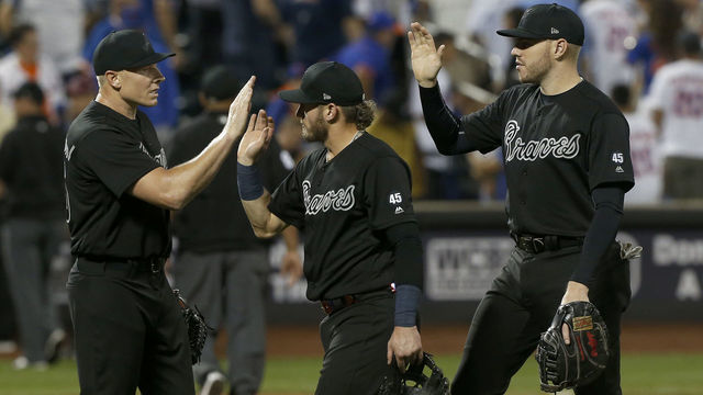 NEW YORK, NEW YORK - AUGUST 23: (L-R) Mark Melancon #36, Josh Donaldson #20 and Freddie Freeman #5 of the Atlanta Braves celebrate after defeating the New York Mets in fourteen innings at Citi Field on August 23, 2019 in New York City. Teams are wearing special color schemed uniforms with players choosing nicknames to display for Players Weekend.