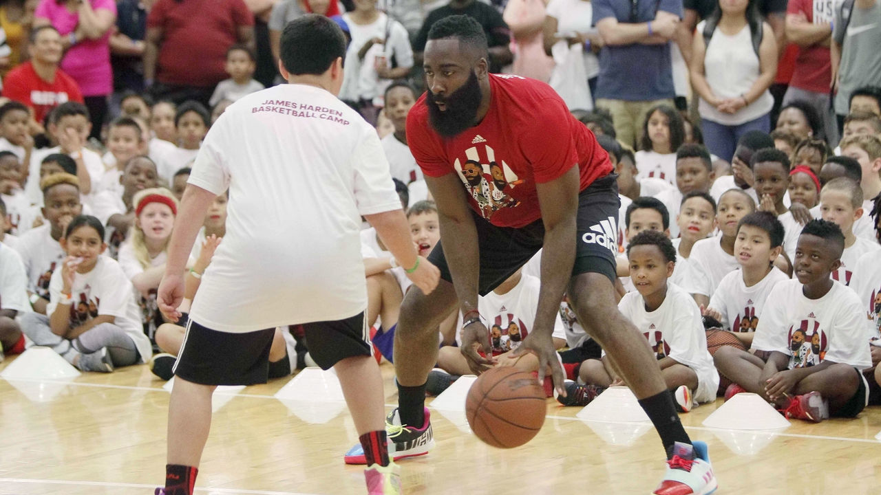 HOUSTON, July 21, 2019 -- NBA Houston Rockets player James Harden plays with a kid during the James Harden Basketball Camp in Houston, the United States, July 20, 2019,