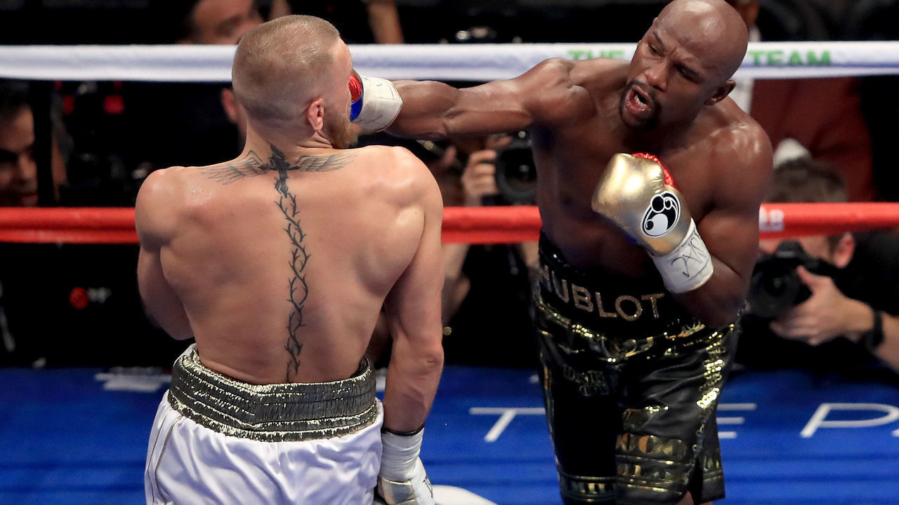 LAS VEGAS, NV - AUGUST 26: (R-L) Floyd Mayweather Jr. throws a punch at Conor McGregor during their super welterweight boxing match on August 26, 2017 at T-Mobile Arena in Las Vegas, Nevada.