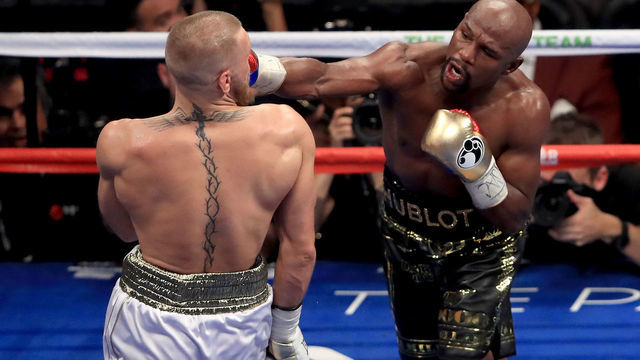 LAS VEGAS, NV - AUGUST 26: (R-L) Floyd Mayweather Jr. throws a punch at Conor McGregor during their super welterweight boxing match on August 26, 2017 at T-Mobile Arena in Las Vegas, Nevada.