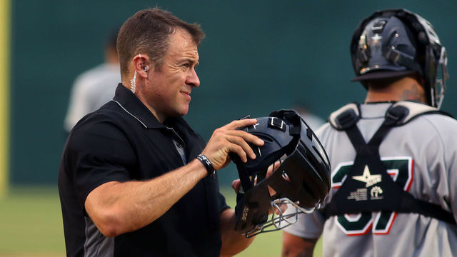 NEW BRITAIN, CT - JULY 30: Home plate umpire Timothy Rosso wears an earpiece in which he hears the balls and strikes called as he puts on his helmet and mask in the 4th inning of a game at New Britain Stadium in New Britain, CT on July 30, 2019. For the first time, the independent Atlantic League is experimenting with "robo-umpires" during a game between the home team, New Britain Bees, and the Long Island Ducks. The home plate umpire, Timothy Rosso wore an earpiece in which he heard the balls and strikes called. Last month, the independent Atlantic League announced that, in partnership with Major League Baseball, it would be implementing a number of experimental rule changes for the remainder of its season, with the idea they might eventually be adopted at the games highest level. Of those rule changes, none has generated the same type of heated reaction as TrackMan, a computerized system that uses Doppler radar to track every pitch and instantly transmits the result - ball or strike - to an earpiece worn by the home plate umpire.
