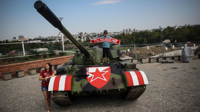 Red Star fans pose on a former Yugoslav army T-55 tank parked at the northern grandstand of the Rajko Mitic stadium in Belgrade on August 27, 2019. - Red Star Belgrade fans stirred controversy after parking an army tank outside their stadium ahead of their Champions League play-off second leg against Swiss side Young Boys on August 27, 2019. The tank, a refurbished T-55 purchased from an army depot, was parked outside the stadium as an "attraction", the Serbian club said on their Facebook page.