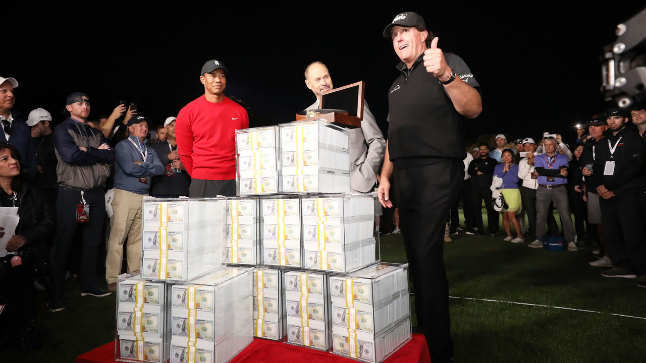 LAS VEGAS, NV - NOVEMBER 23: Phil Mickelson celebrates with the winnings after defeating Tiger Woods as Ernie Johnson looks on during The Match: Tiger vs Phil at Shadow Creek Golf Course on November 23, 2018 in Las Vegas, Nevada.