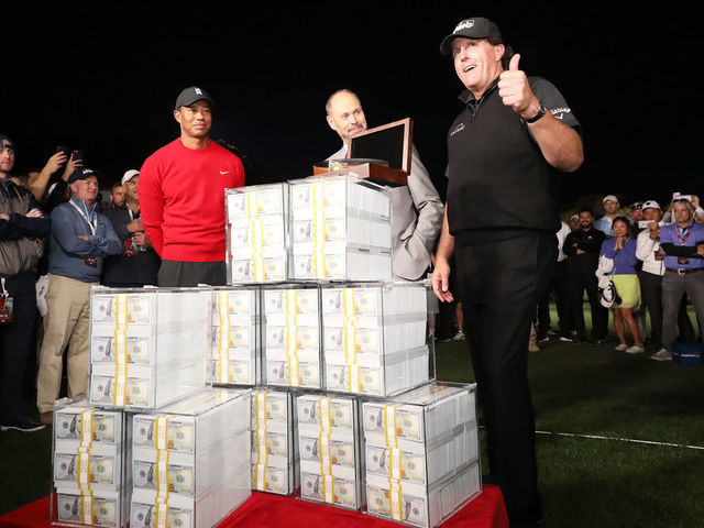 LAS VEGAS, NV - NOVEMBER 23: Phil Mickelson celebrates with the winnings after defeating Tiger Woods as Ernie Johnson looks on during The Match: Tiger vs Phil at Shadow Creek Golf Course on November 23, 2018 in Las Vegas, Nevada.