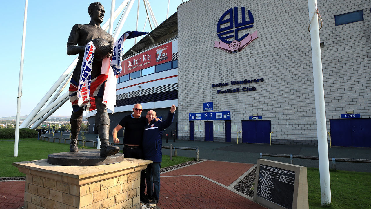 Fans near the statue Nat Lofthouse at the University of Bolton Stadium, Bolton.