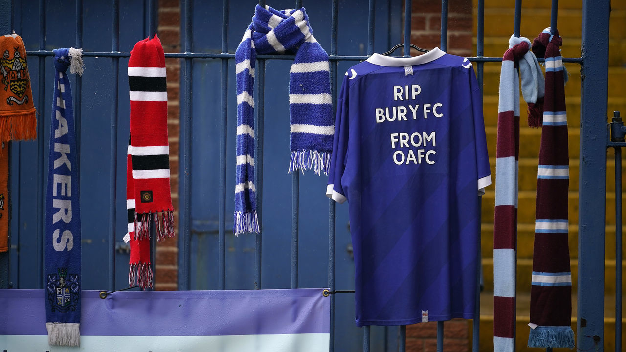 BURY, ENGLAND - AUGUST 28: Football scarves hang from the locked gates of Gigg Lane Stadium the home of Bury Football Club who have been expelled from the English Football League (EFL) on August 28, 2019 in Bury, England. After an historic membership of 125 years the EFL have expelled Bury FC after a buyer for the club was not secured.