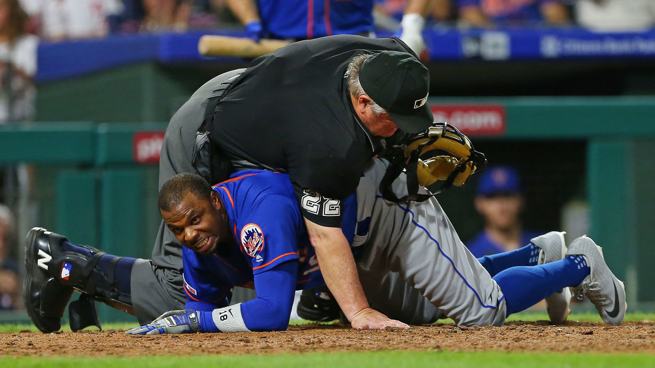 PHILADELPHIA, PA - SEPTEMBER 01: Home plate umpire Joe West #22 falls on top of Rajai Davis #18 of the New York Mets after he was tagged out by catcher J.T. Realmuto #10 of the Philadelphia Phillies as he attempted to score on a fielder's choice hit by Jeff McNeil #6 during the eighth inning of a game at Citizens Bank Park on September 1, 2019 in Philadelphia, Pennsylvania. The Phillies defeated the Mets 5-2.