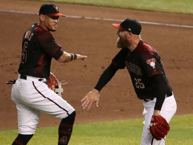PHOENIX, ARIZONA - AUGUST 31: Relief pitcher Archie Bradley #25 of the Arizona Diamondbacks celebrates with Ildemaro Vargas #15 after defeating the Los Angeles Dodgers 6-5 in the MLB game at Chase Field on August 31, 2019 in Phoenix, Arizona.