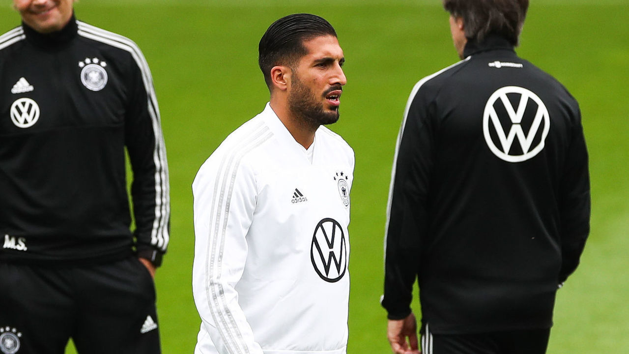 04 September 2019, Hamburg: Soccer: national team, training Germany before the European Championship qualifier Germany - Netherlands in the stadium at Millerntor. Emre Can walks across the square. In the background are national coach Joachim Löw (r) and assistant coach Marcus Sorg. Photo: Christian Charisius/dpa