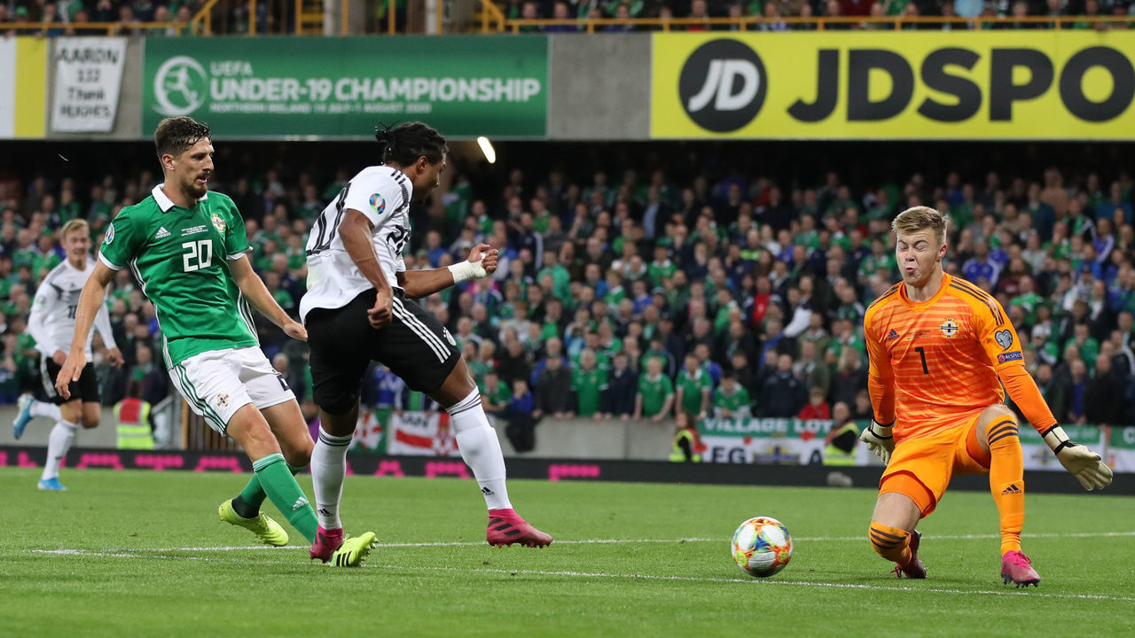 09 September 2019, Great Britain, Belfast: Soccer: European Championship qualification, group stage, group C, 6th matchday: Northern Ireland - Germany at Windsor Park Stadium. Serge Gnabry (M) from Germany scores the goal for 0:2 against goalkeeper Bailey Peacock-Farrell (r) from Northern Ireland. IMPORTANT NOTE: In accordance with the requirements of the DFL Deutsche Fußball Liga or the DFB Deutscher Fußball-Bund, it is prohibited to use or have used photographs taken in the stadium and/or the match in the form of sequence images and/or video-like photo sequences. Photo: Christian Charisius/dpa