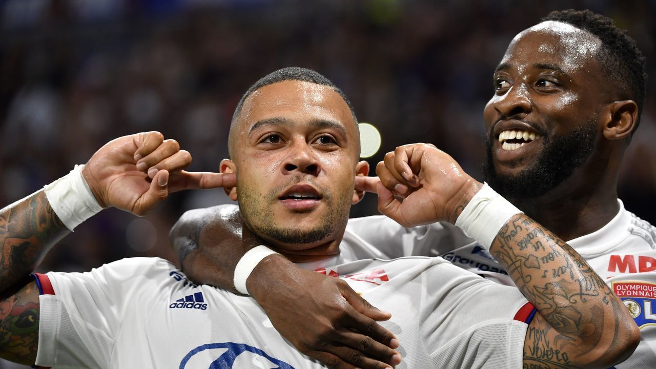 Lyon's Dutch forward Memphis Depay (C) is congratuled by teamate Lyon's French forward Moussa Dembele (R) after scoring a goal celebrates after scoring a goal during the French L1 football match between Olympique Lyonnais (OL) and Angers SCO on August 16, 2019 at the Parc Olympique Lyonnais stadium in Decines-Charpieu, central-eastern France.