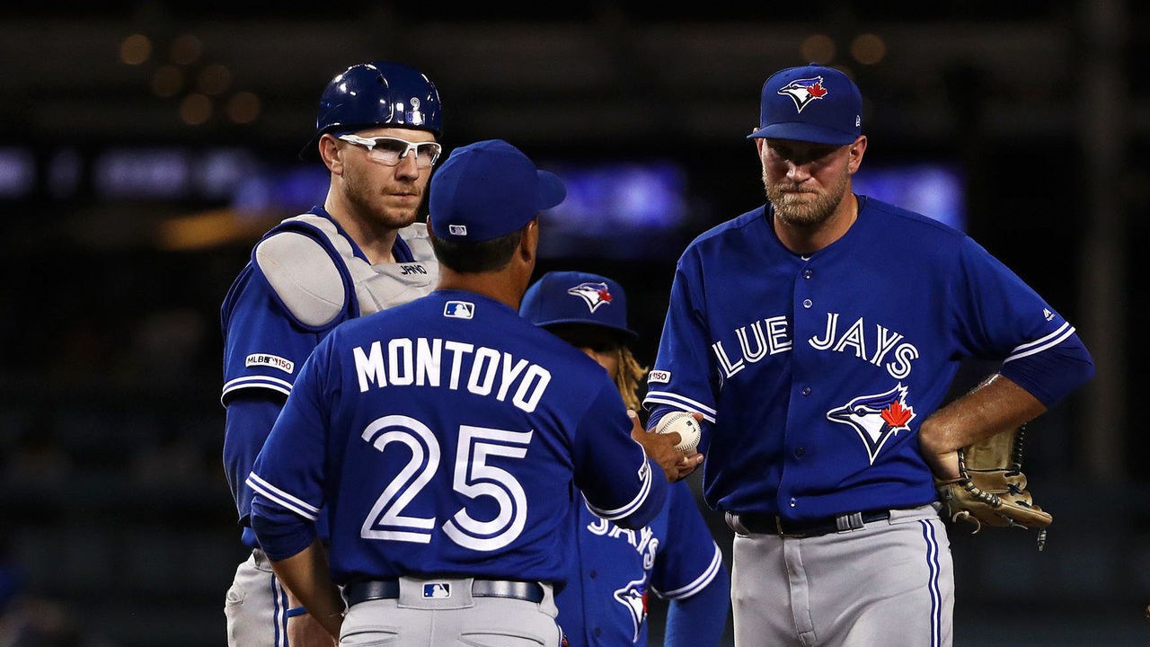 LOS ANGELES, CALIFORNIA - AUGUST 20: Relief pitcher Justin Shafer #50 of the Toronto Blue Jays hands the ball to manager manager Charlie Montoyo #25 before leaving the game in the sixth inning of the MLB game at Dodger Stadium on August 20, 2019 in Los Angeles, California.