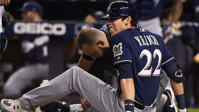 MIAMI, FLORIDA - SEPTEMBER 10: Christian Yelich #22 of the Milwaukee Brewers is checked out by the medical staff after an injury from ball deflection in the first inning against the Miami Marlins at Marlins Park on September 10, 2019 in Miami, Florida.