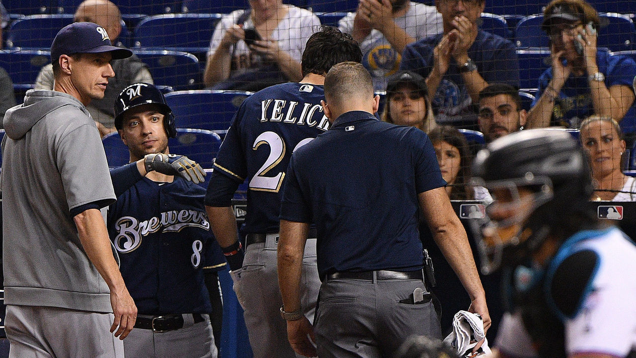 MIAMI, FLORIDA - SEPTEMBER 10: Christian Yelich #22 of the Milwaukee Brewers is checked out by the medical staff after an injury from ball deflection in the first inning against the Miami Marlins at Marlins Park on September 10, 2019 in Miami, Florida.